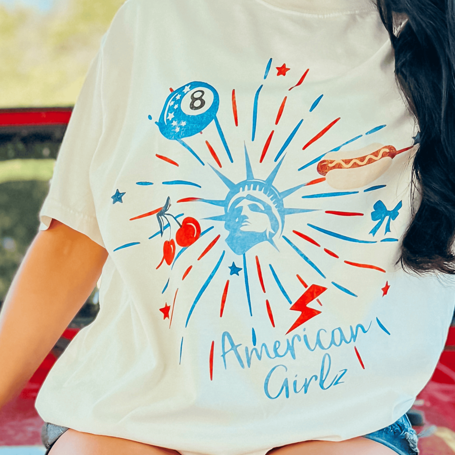 American Girlz tee featuring a colorful graphic with the Statue of Liberty, stars, and an 8-ball design.